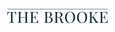 Text logo reading "THE BROOKE" in uppercase serif font, with a line above the text on a light background.