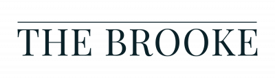 Text logo reading "THE BROOKE" in uppercase serif font, with a line above the text on a light background.
